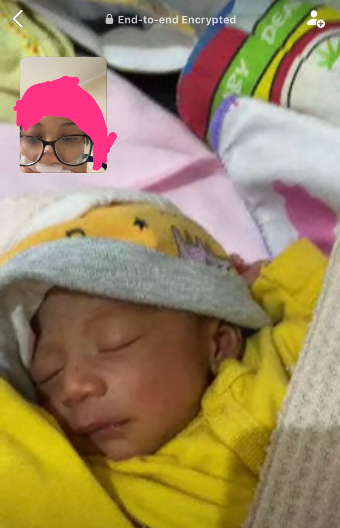 A woman appears on videocall with her newborn baby.