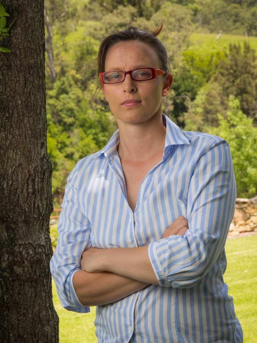 Sarah Sivyer stands next to a tree.