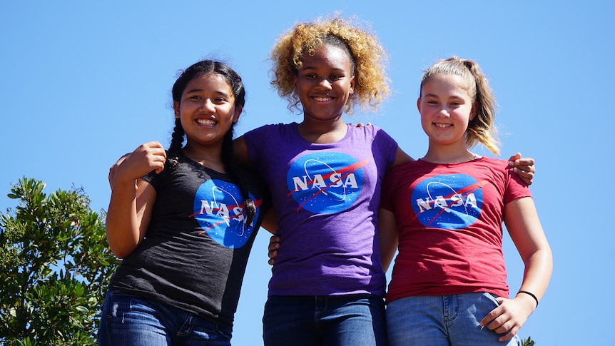 Three teenage girls pose for photo wearing NASA tshirts