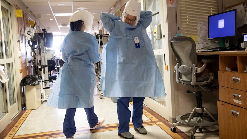 Nurse Kate Knepprath dons PPE as she prepares to enter the room of a coronavirus disease (COVID-19) patient.