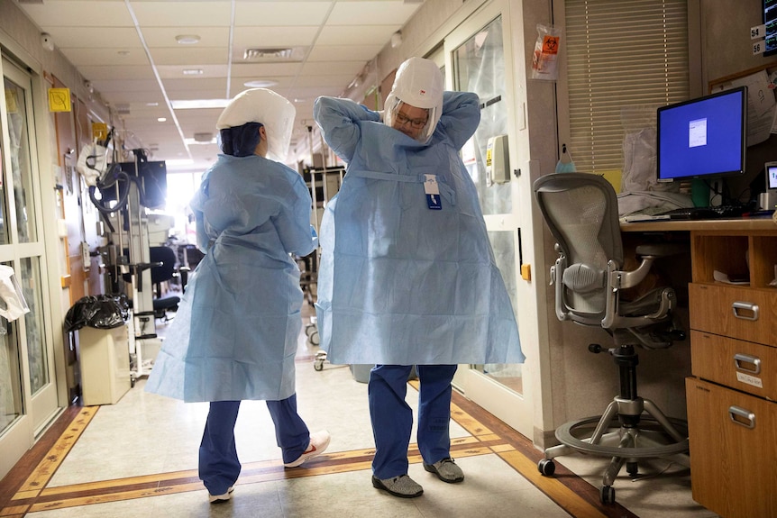 Nurse Kate Knepprath dons PPE as she prepares to enter the room of a coronavirus disease (COVID-19) patient.