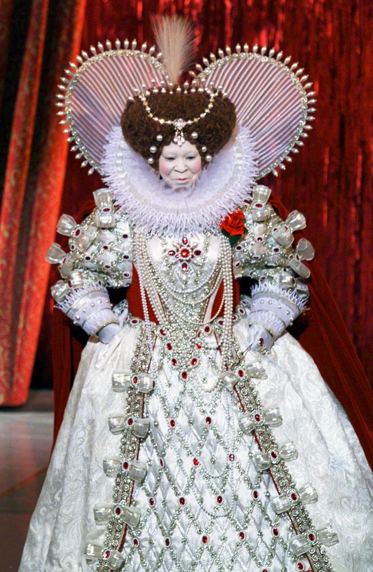 Whoopi Goldberg appears as Queen Elizabeth the First, in an ornate embroidered white costume.