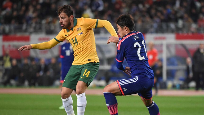 James Troisi of Australia keeps the ball under the pressure from Kosuke Ota of Japan during the international friendly match between Japan and Australia