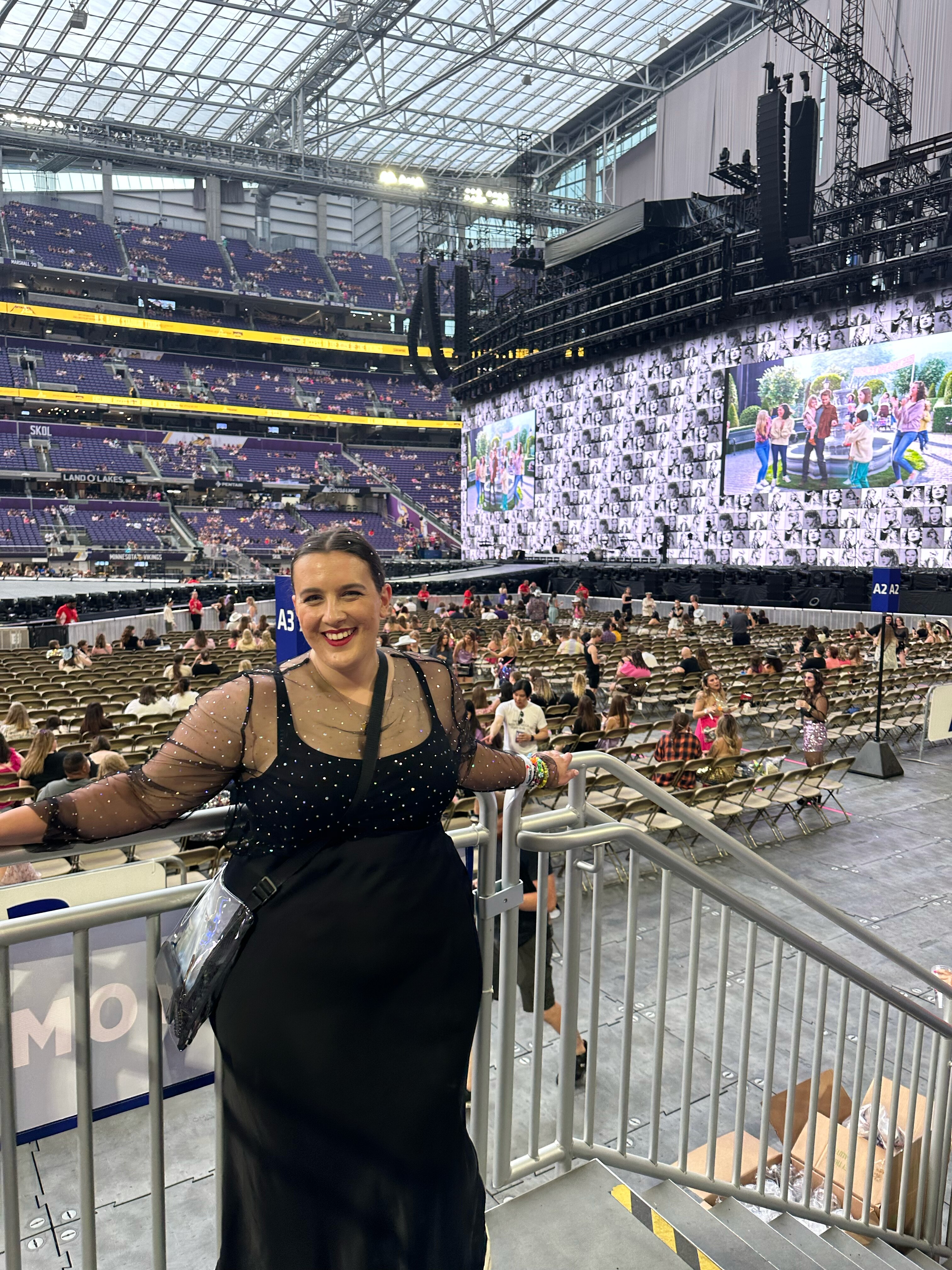 Picture of Kate Pattison, who has brown hair and is wearing a black dress, at a Taylor Swift concert.