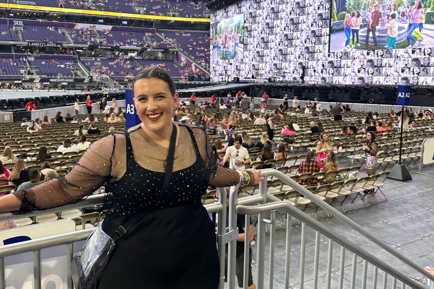 Picture of Kate Pattison, who has brown hair and is wearing a black dress, at a Taylor Swift concert.