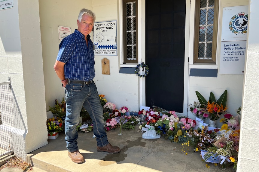 Mayor Patrick Ross looking at the flower tributes laid out the front of the Lucindale police station.