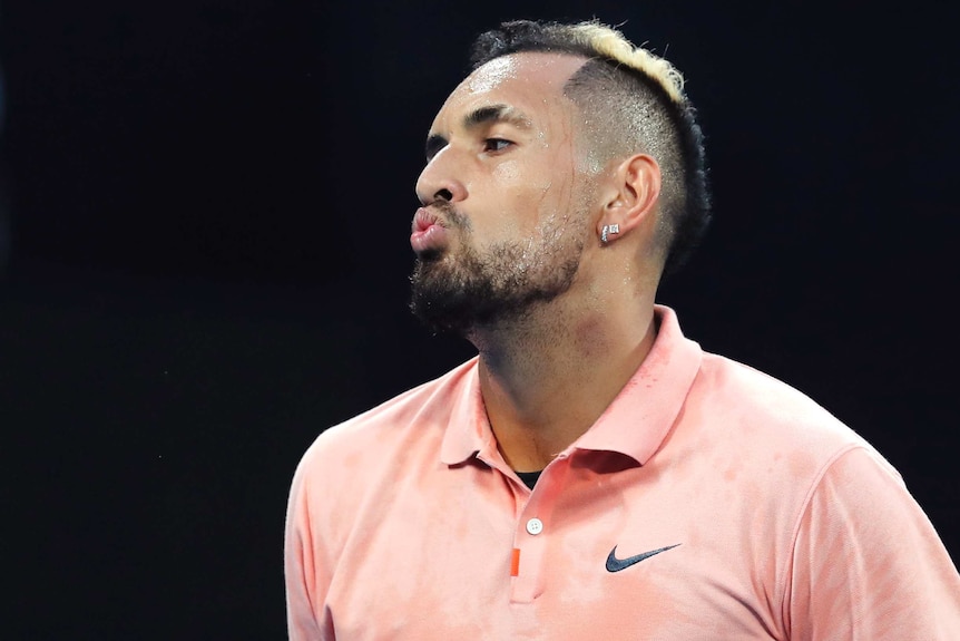 A male tennis player makes a facial expression during a match at the Australian Open.