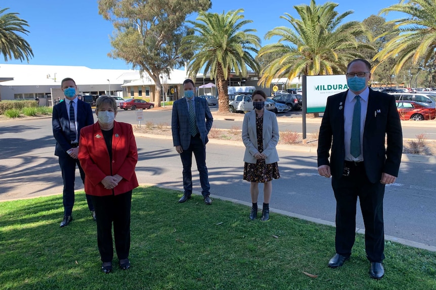 five people wearing masks and stand socially distanced in front of the Mildura Base Hospital building