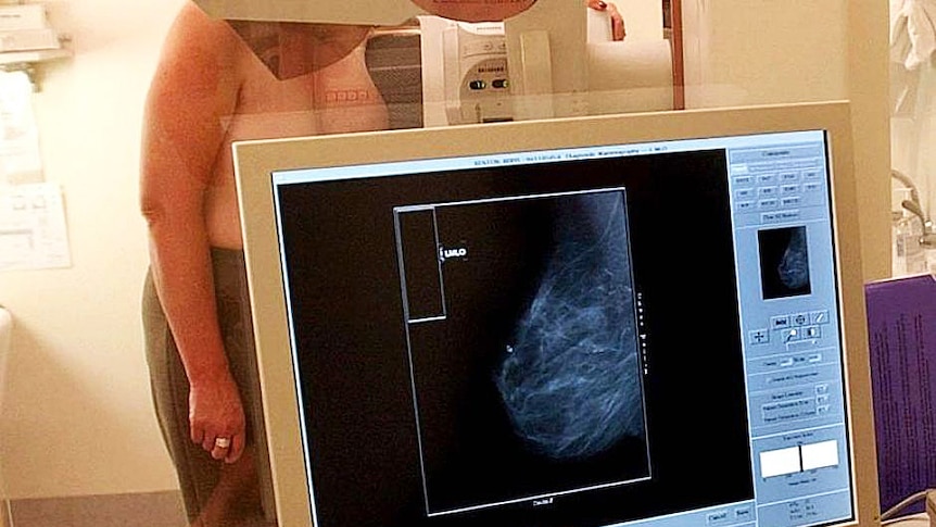 A woman gets her breasts scanned.