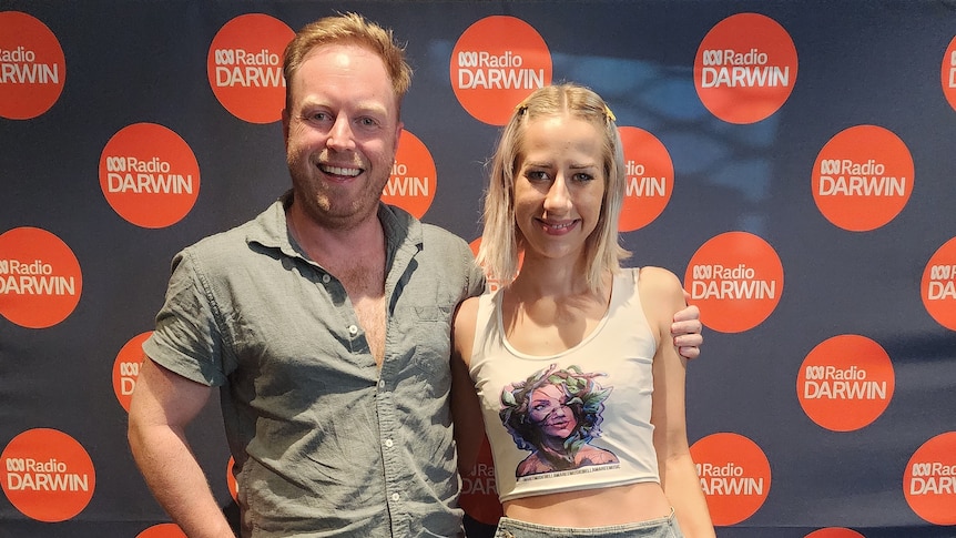 Man with woman against ABC Darwin banner