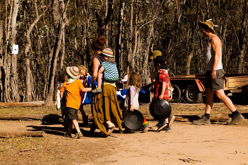 A family at a music festival, carrying gold pans.