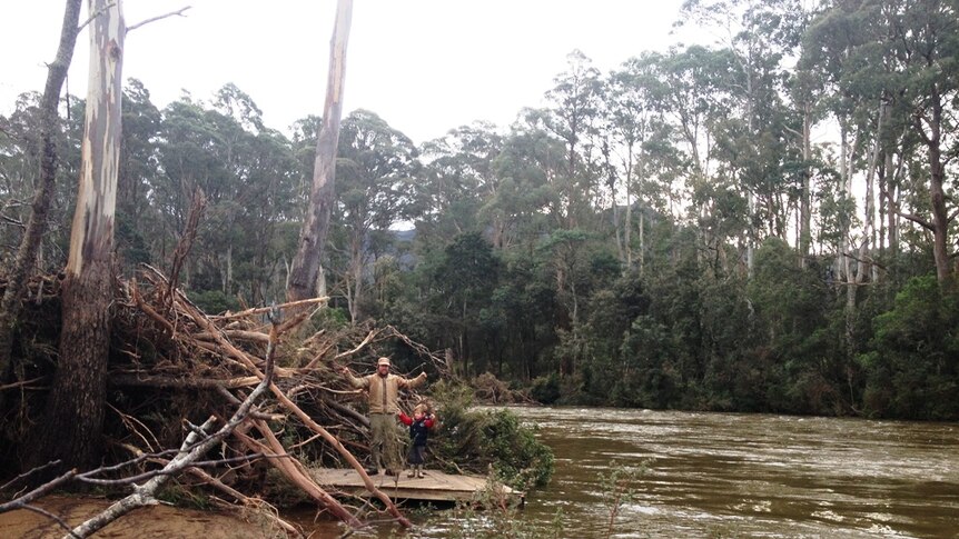 Damian Atkins and son Harvey find their deck in amongst the flood debris.