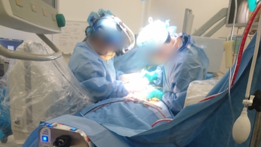 Two doctors work on a patient at a hospital.