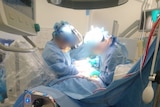 Two doctors work on a patient at a hospital.