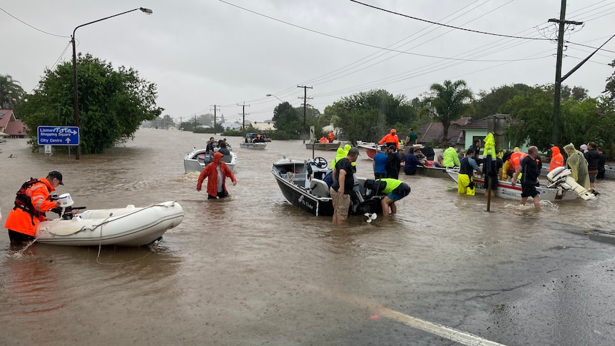 people walking out of floodwaters