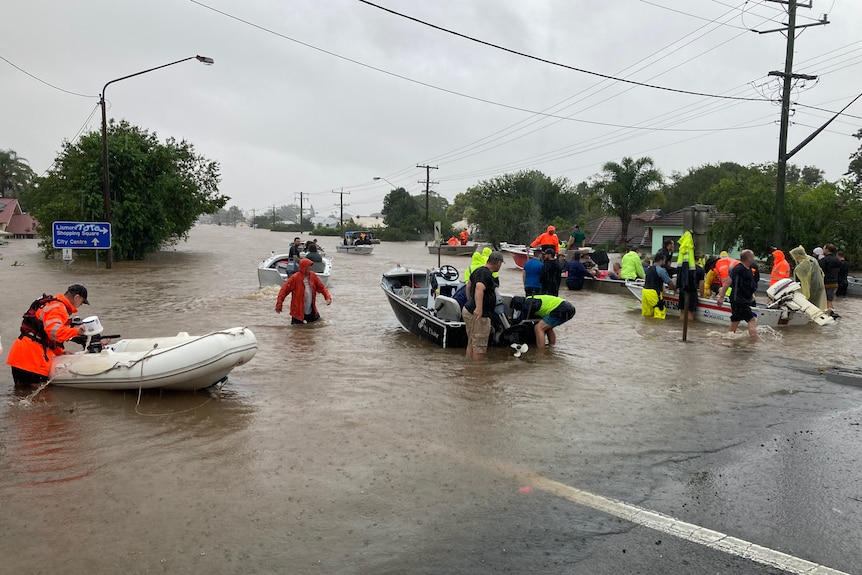 people walking out of floodwaters