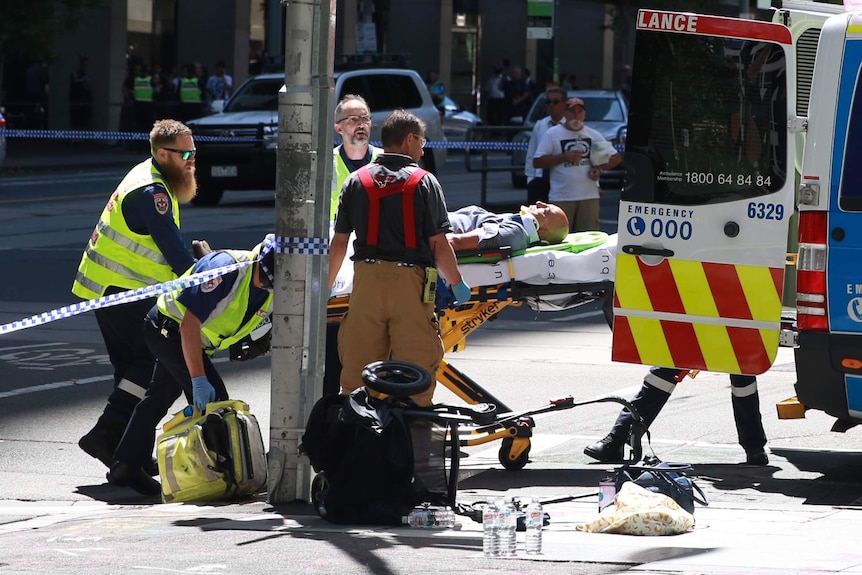 A pram is seen knocked over and a man is stretchered by paramedics