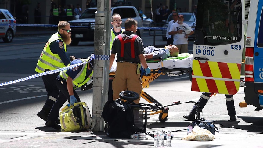 A pram is seen knocked over and a man is stretchered by paramedics