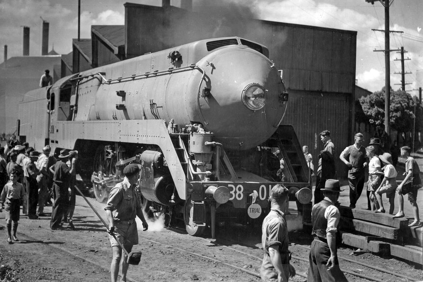 Black and white photo of steam train in railway yard.