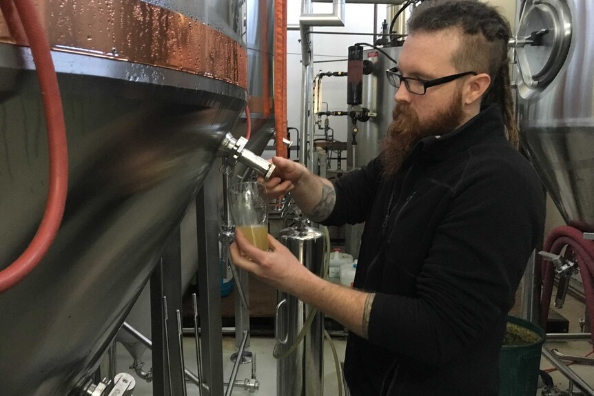 Daniel Shaw pouring a beer at his Western Sydney brewery.