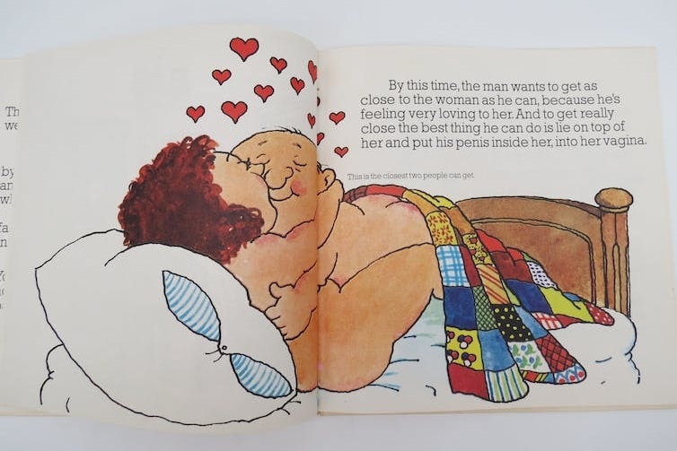 A page from a sex education picture book, with an illustration of two adults having sex in bed. 