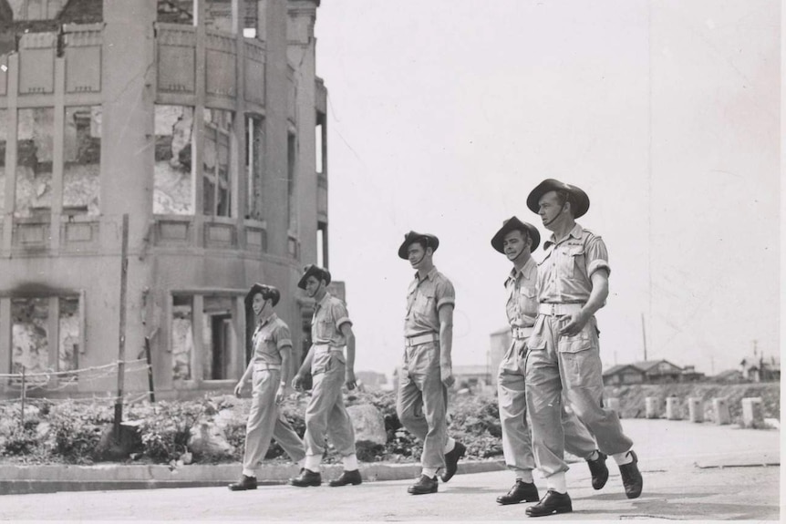 A black and white photo of five Australian soldiers walking in Hiroshima, Japan.