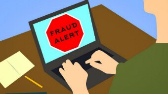 A cartoon of a person using a laptop with the words "fraud alert" in a red stop sign.
