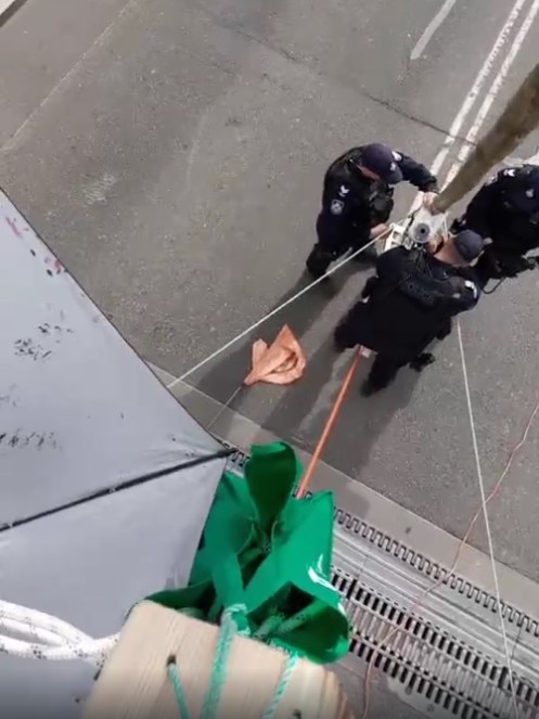 View from the top of a tripod where a protester is suspended above Victoria Bridge.