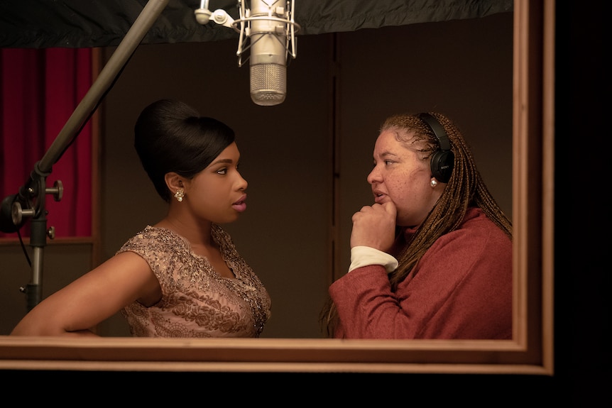 Jennifer Hudson listens intently to feedback from director Liesl Tommy in a dimly lit recording studio on the set of Respect.