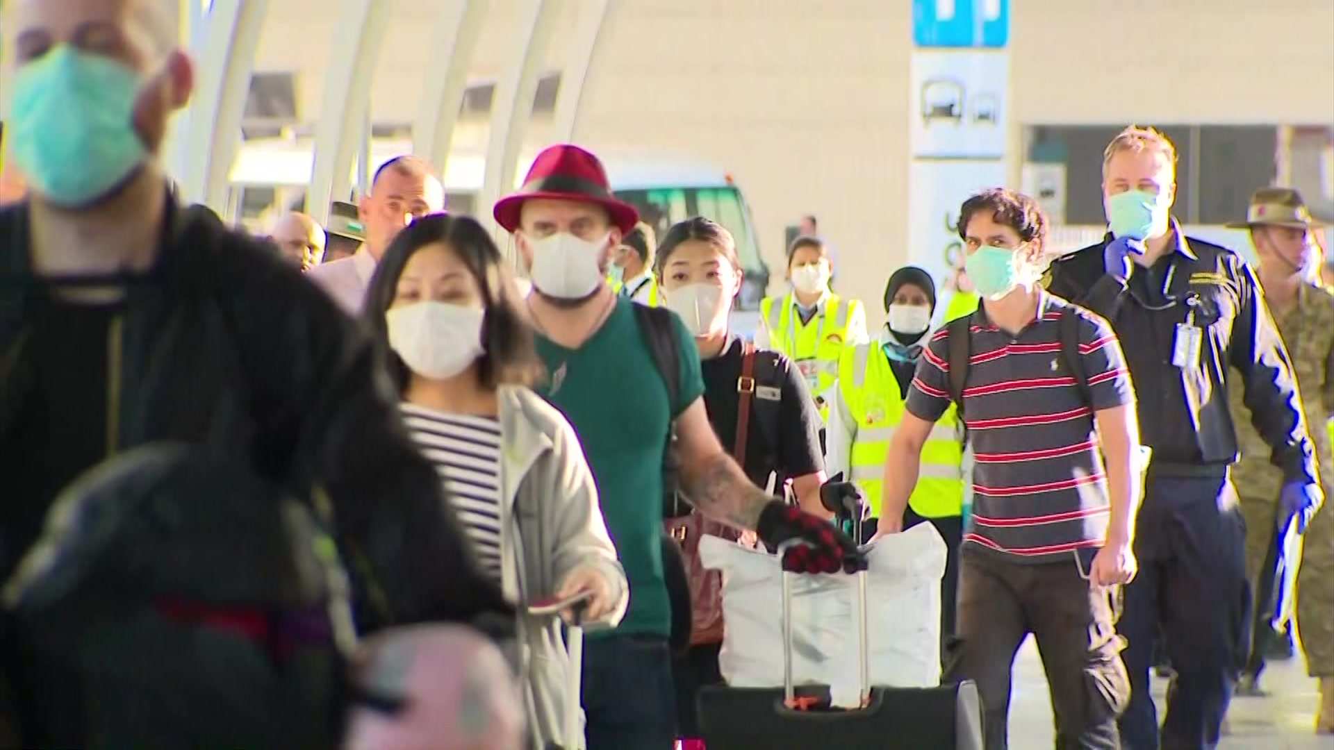 A line of passengers wearing masks.