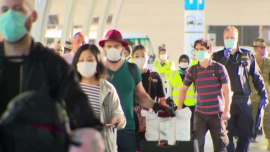 A line of passengers wearing masks.