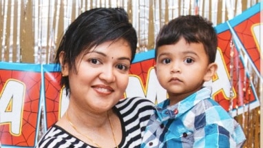 A woman wearing a striped shirt holding a male toddler