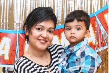 A woman wearing a striped shirt holding a male toddler