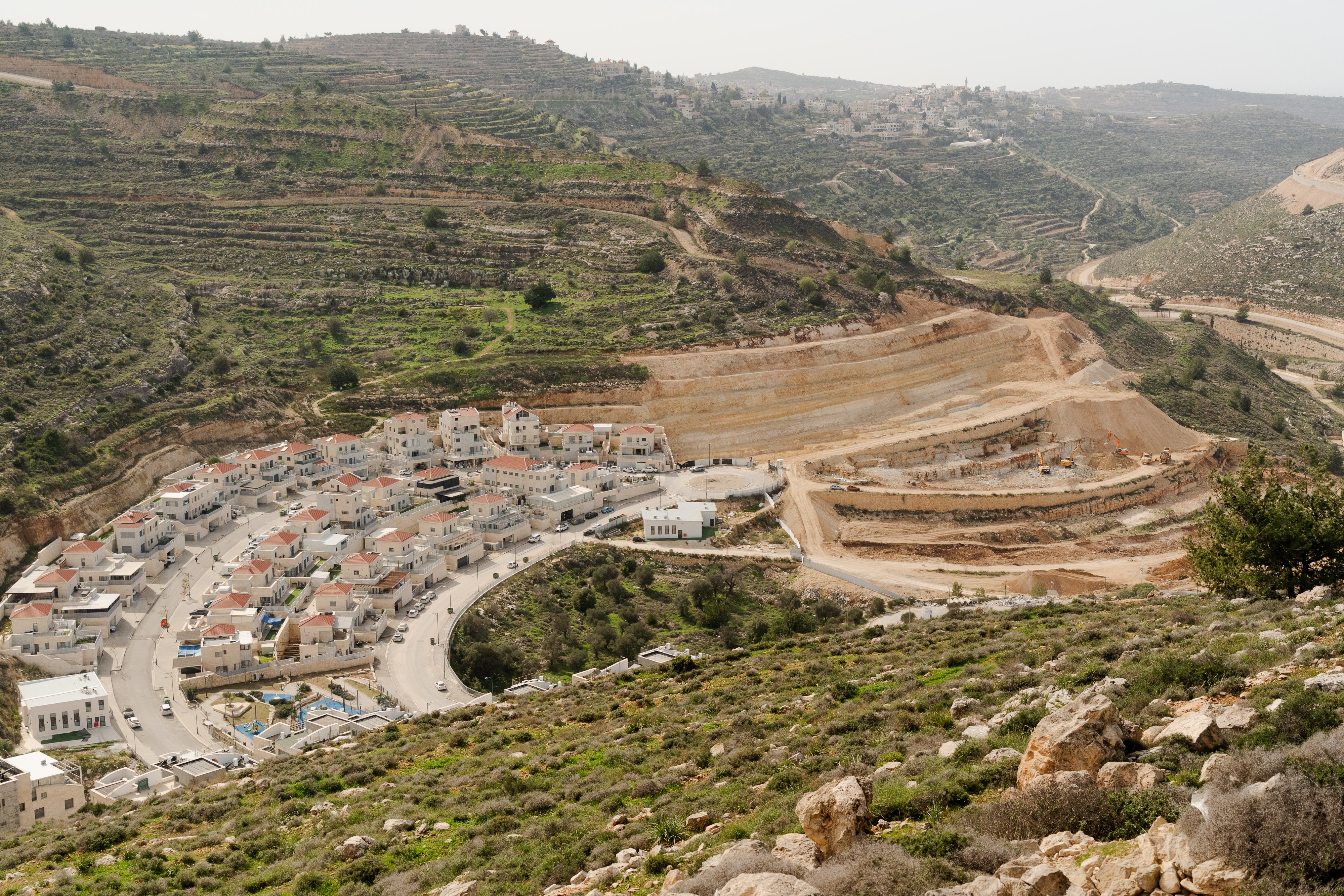 A drone view of houses build along a cliff face.