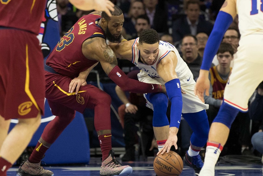Ben Simmons chases for the ball under pressure from LeBron James
