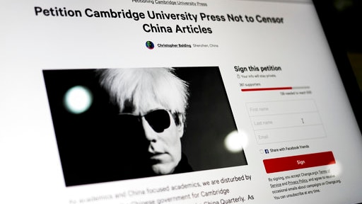 A computer screen shows an online petition page urging Cambridge University Press to restore more than 300 blocked articles.