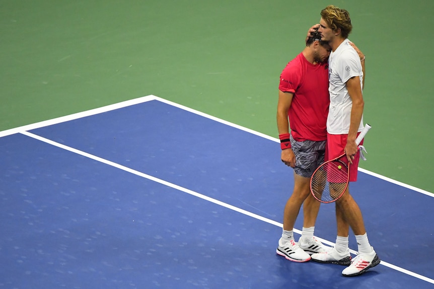 Alexander Zverev embraces Dominic Thiem on the court.