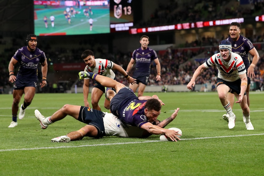 A man reaches out to score in a rugby league match