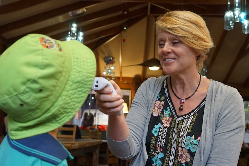 A child has their temperature taken by a child care worker.