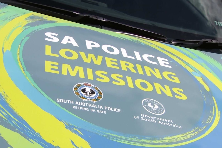 A bonnet of a car with the words SA POLICE LOWERING EMISSIONS on it
