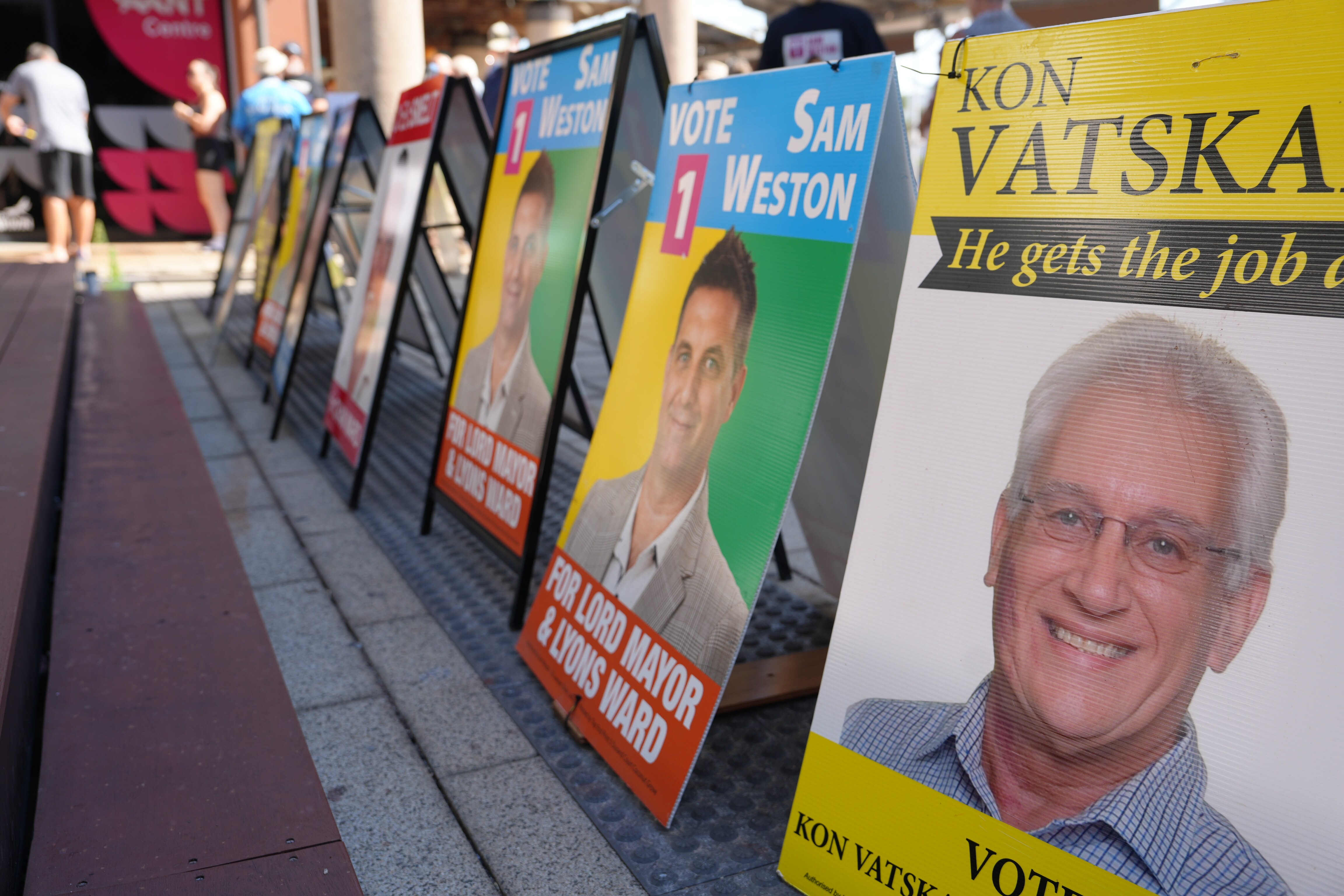 A row of local council placards lined up outside a polling booth.