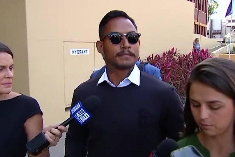 Ben Barba leaving Mackay Magistrates Court with journalists holding microphones.