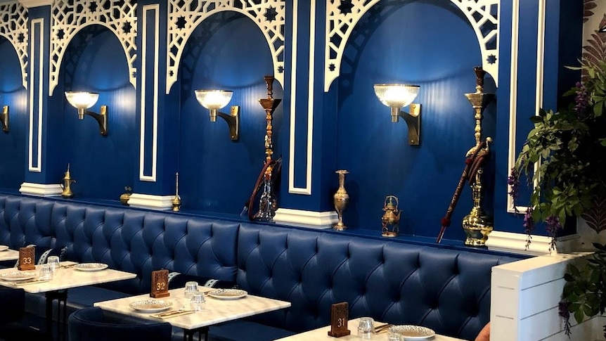 an empty restaurant with shisha pipes on the walls