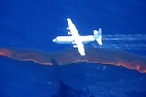 A Hercules aircraft from the Australian Maritime Safety Authority drops dispersant
