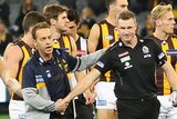 Mark of respect ... Alastair Clarkson (L) and Nathan Buckley shake hands after both the Hawks and Magpies paid respect to Phil Walsh