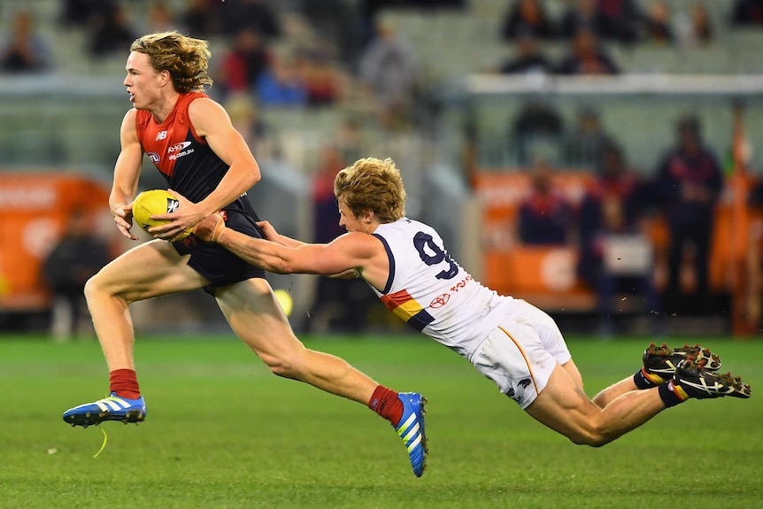 Melbourne's Jayden Hunt is tackled by Adelaide's Rory Sloane at the MCG on July 3, 2016.