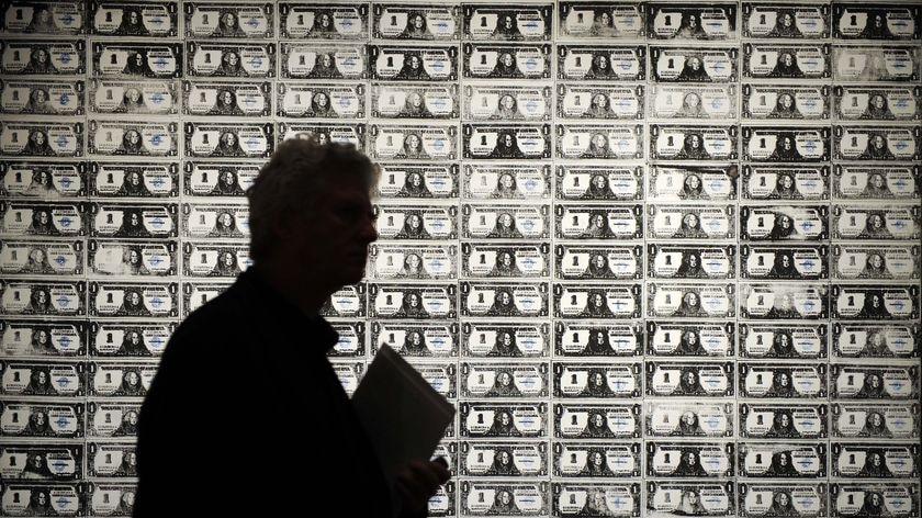 A man walks past '200 One Dollar Bills' by Andy Warhol