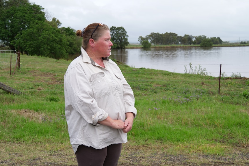 A woman looking at a flooded paddock