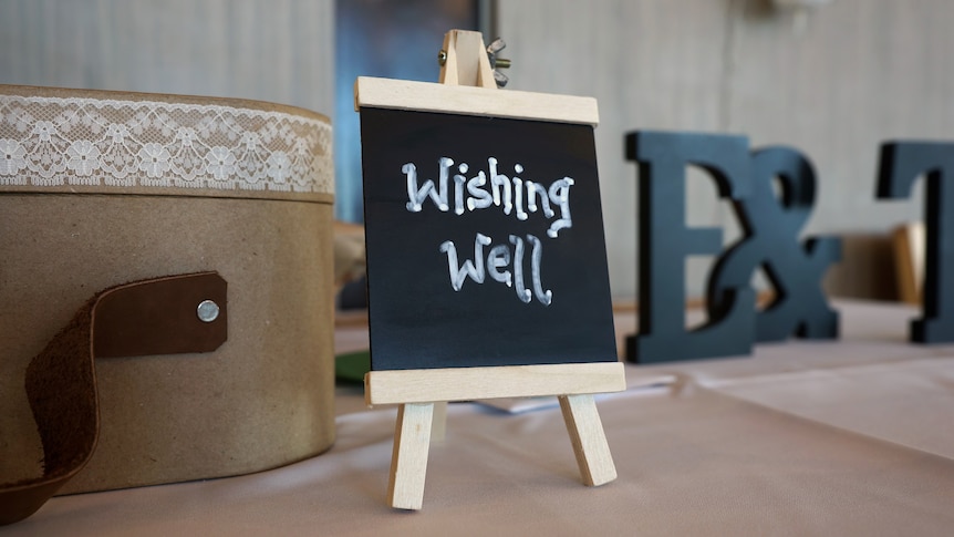 Blackboard with wishing well written in text on a wedding reception table
