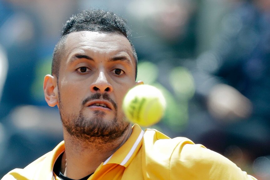 A tennis player eyes the ball intently.